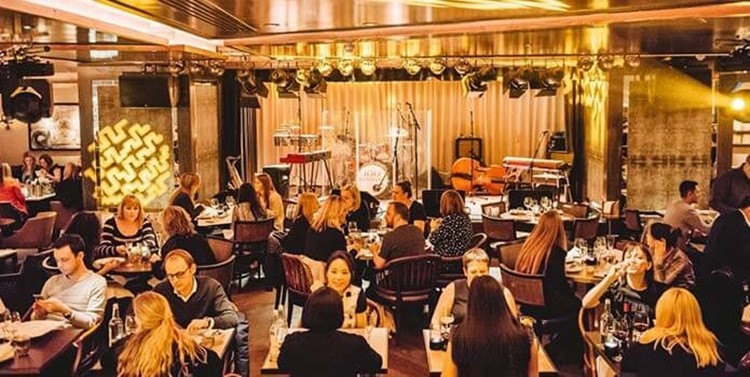 100 wardour st london view of the club and main stage with instrument ready for a concert show people sitting at tables drinking and talking