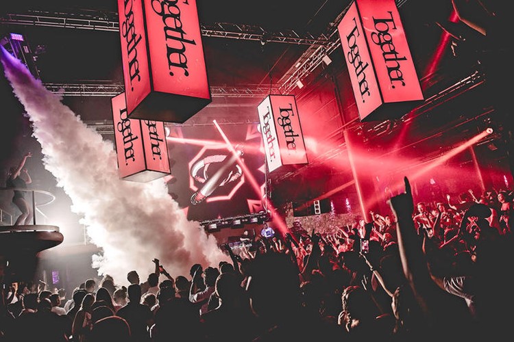 amnesia nightclub ibiza spectacular concert with special effects and colored red lights crowd singing and dancing with exotic dancers on balcony