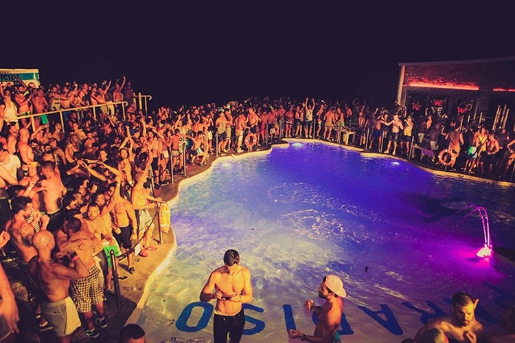 Cavo Paradiso nightclub Mykonos full crowd partying next to the centered swiming pool people in bikinies having fun