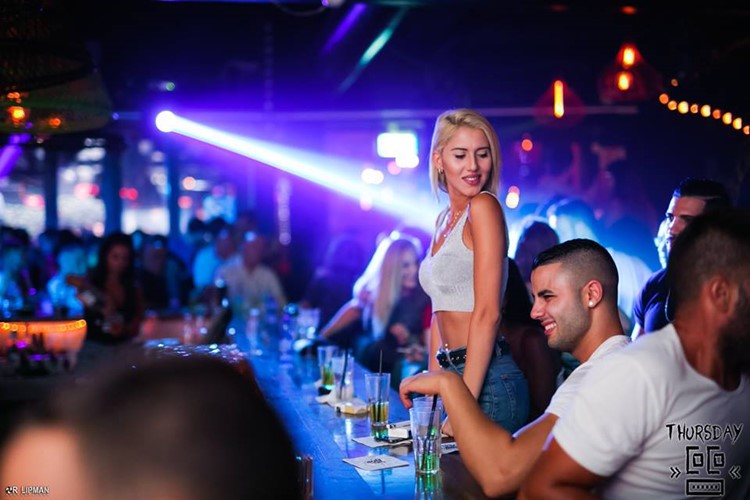 Coco nightclub Tel Aviv pretty blonde girl drinking having fun at party bar view