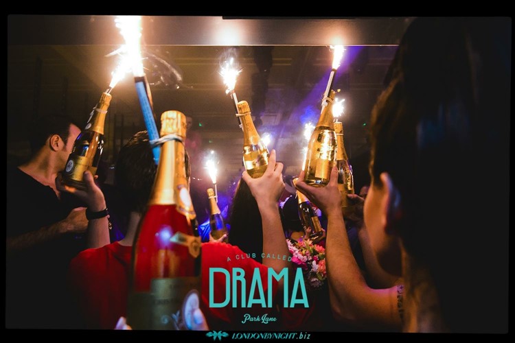 Drama nightclub london champagne and alcohol bottles being served at a vip private table party people having fun and drinking