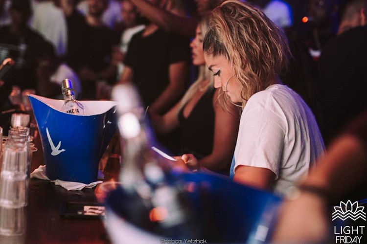 Light House nightclub Tel Aviv blonde girl next to champagne bottle holders drinking
