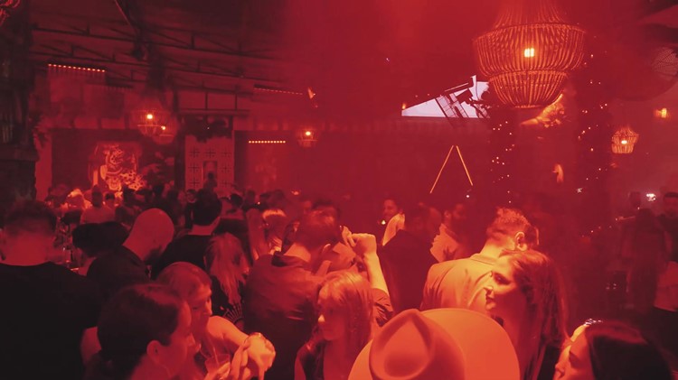 Mayami Wynwood interior in red light with tables and wicker pendant lights