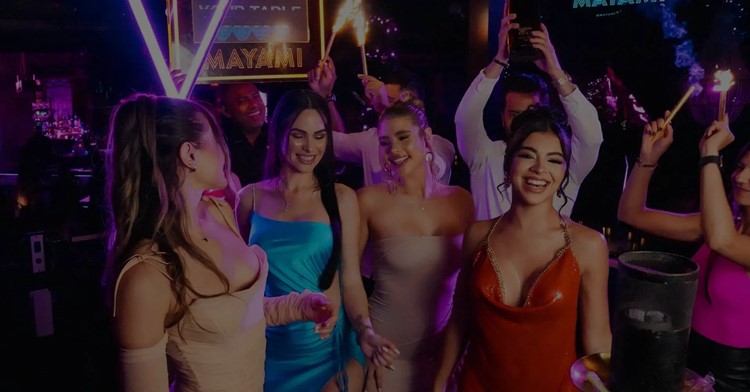 Guests celebrating with sparklers under the neon sign at Mayami Wynwood