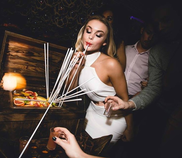mahiki kensington nightclub london beautiful blonde girls wearing going out makeup dressed in white tight white dress drinking from a straw alcohol drinks