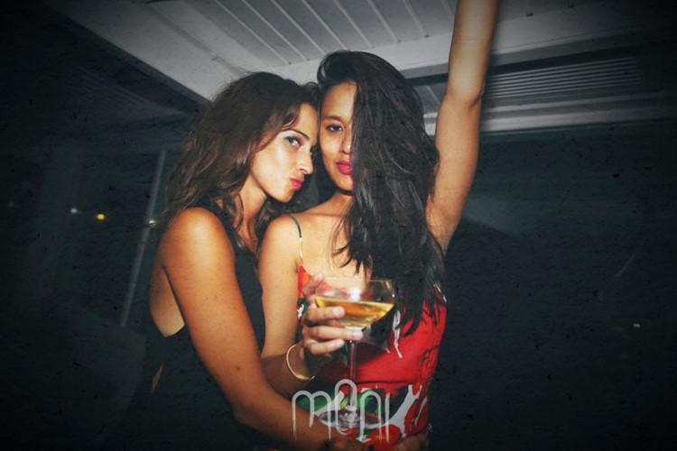 Moni nightclub Mykonos two pretty brunette girls drinking and having fun