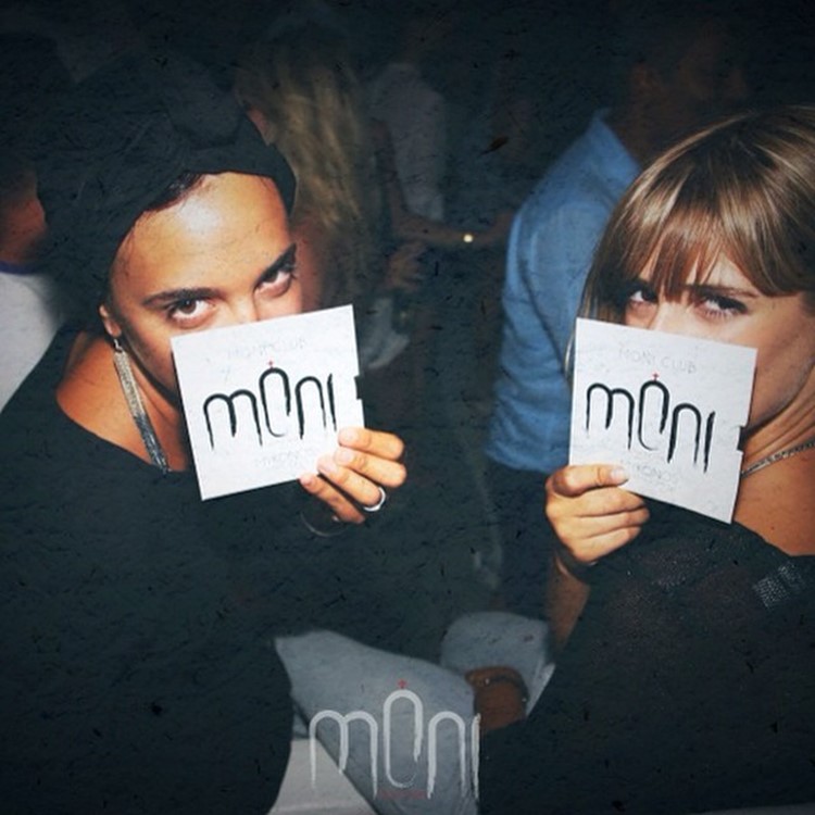 Moni nightclub Mykonos girls showing club's signature on cardboards