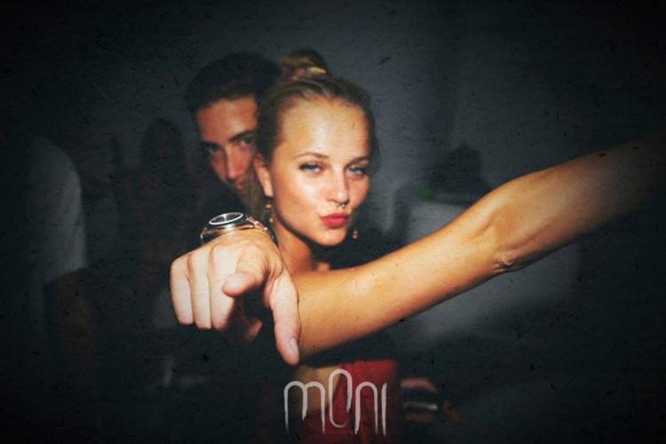 Moni nightclub Mykonos beautiful blonde girl with red lipstick and red dress having fun with a man