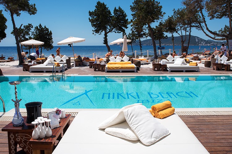 Nikki Beach beachclub Ibiza view of the swimming pool and lounge area palm trees