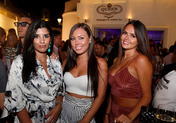 Queen of Mykonos nightclub pretty brunette girls having fun dressed in mini dresses showing cleavage