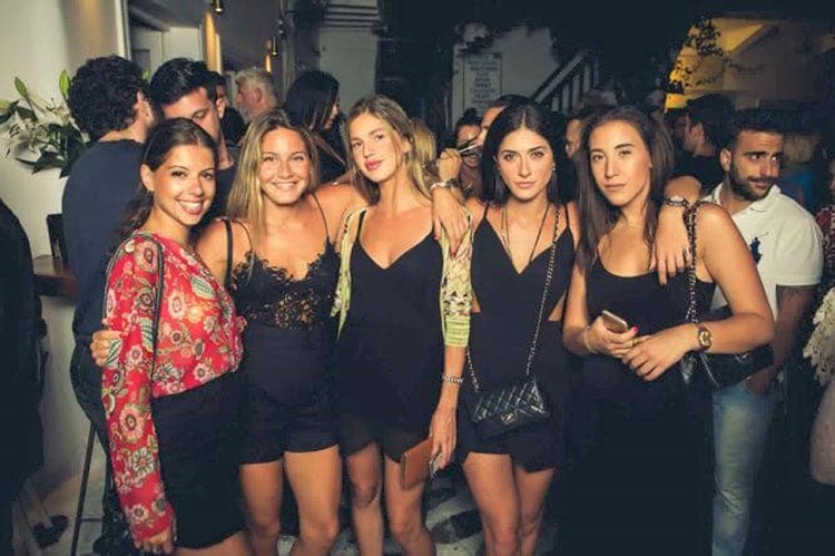 Queen of Mykonos nightclub group of blonde and brunette pretty girls posing dressed in sexy mini black dresses