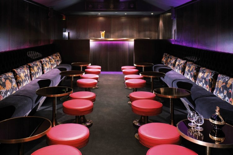 raffles nightclub london view of private tables and couches luxury interior design purple colored lights and furniture