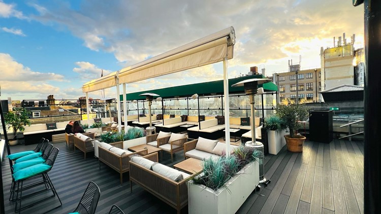 Teal topped bar stools and lounge furniture on the Soho Sky Terrace