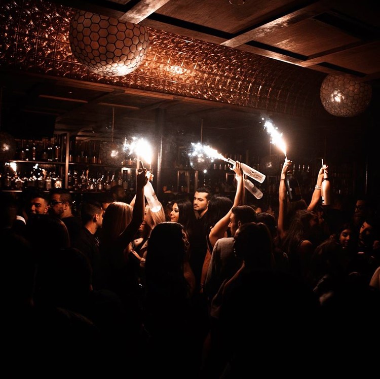 Somwhr Liquor Lounge nightclub Montreal girls holding alcohol drinks champagne full crowd