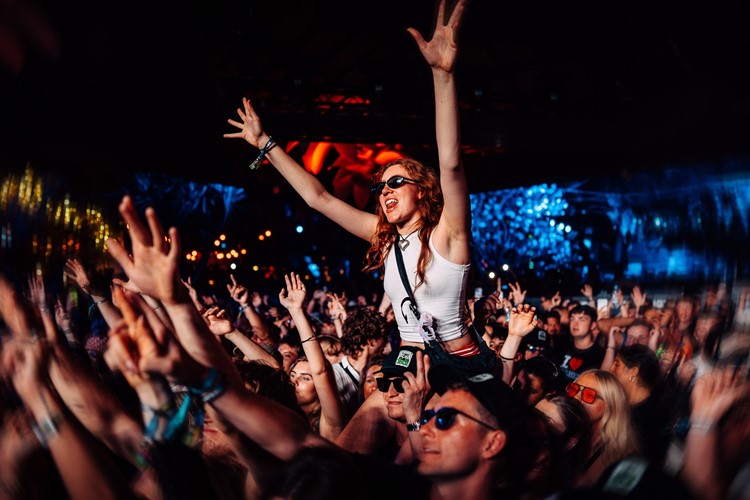 Guest on shoulders above the dense crowd in the dark UNO Malta room