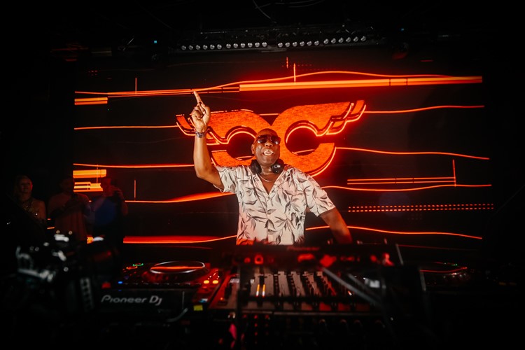 DJ performing in front of the orange UNO wall graphic