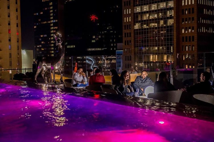 Waterproof nightclub Dallas outside bar swimming pool day club cocktails alcohol bottles reserve table