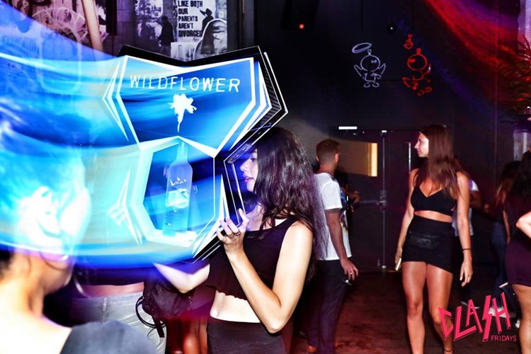 Wildflower nightclub Toronto girl holding alcohol bottles sign