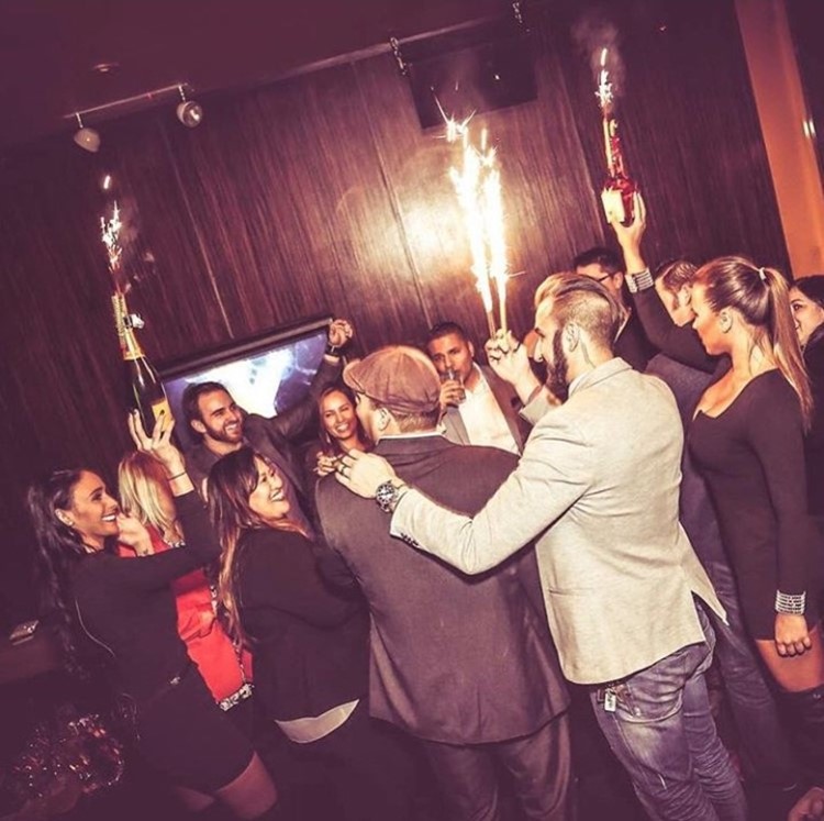 Ybar nightclub Chicago girls and men having fun holding champagne bottles