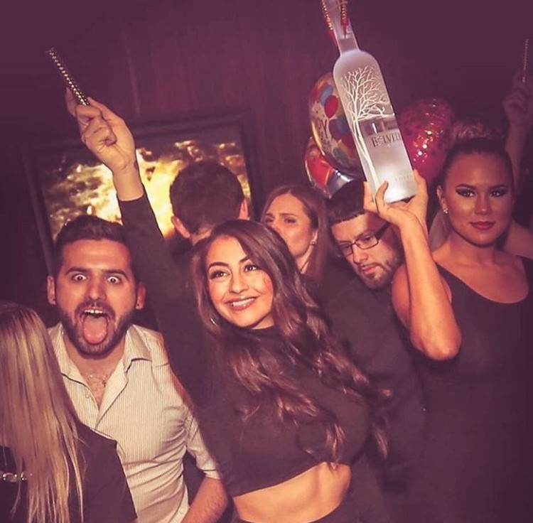 Ybar nightclub Chicago sexy girls holding vodka alcohol bottles